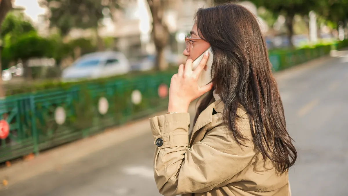 Woman on a phone call in the street, asking about a property